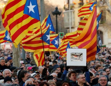 Protestors wave Catalan flags as they await the arrival of former Catalan President Artur Mas outside court in Barcelona, Spain, earlier this year.